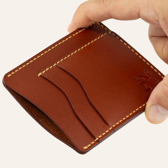 MZ Leather Craft dikey minimalist kiremit Buttero deri kartlık, el ile tutulan hafif açılı boş ön görünüm, kıvrımlı kart yuvaları ve sarı saraç dikişi detayları