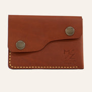 MZ Leather Craft çift çıtçıtlı kapaklı minimalist kiremit Buttero deri cüzdan, kapalı önden görünüm, asimetrik kapak formu, sarı el dikişi ve kabartmalı MZ logosu