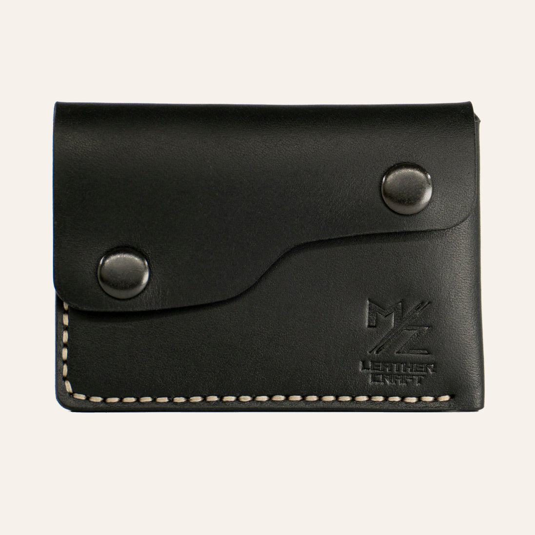 MZ Leather Craft çift çıtçıtlı kapaklı minimalist siyah Buttero deri cüzdan, kapalı önden görünüm, asimetrik kapak formu, açık gri el dikişi ve kabartmalı MZ logosu