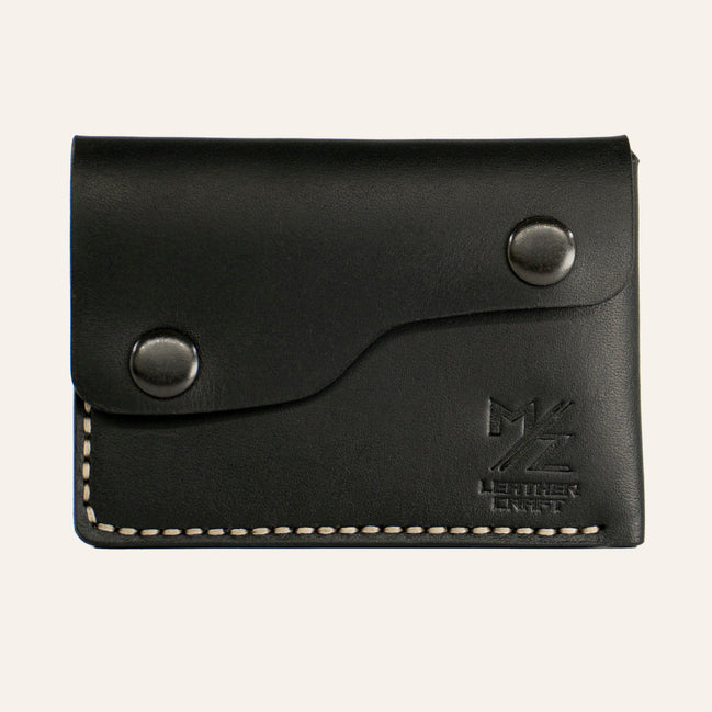 MZ Leather Craft çift çıtçıtlı kapaklı minimalist siyah Buttero deri cüzdan, kapalı önden görünüm, asimetrik kapak formu, açık gri el dikişi ve kabartmalı MZ logosu