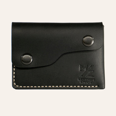 MZ Leather Craft çift çıtçıtlı kapaklı minimalist siyah Buttero deri cüzdan, kapalı önden görünüm, asimetrik kapak formu, açık gri el dikişi ve kabartmalı MZ logosu