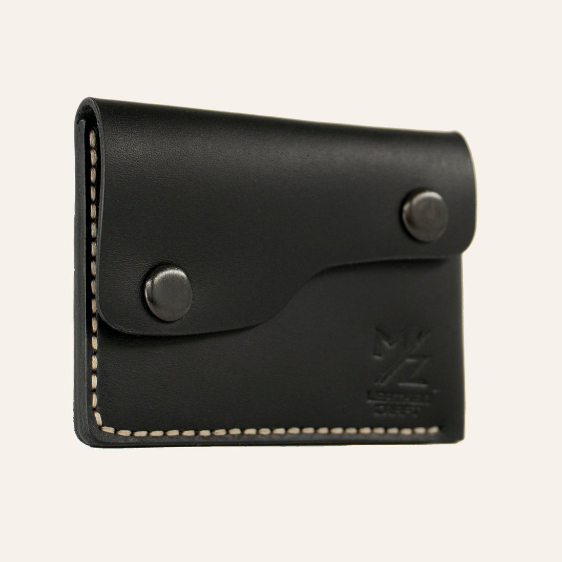 MZ Leather Craft siyah Buttero deri kapaklı minimalist cüzdan, kapalı hafif açılı sol profil görünümü, açık gri el dikişi hattı ve pürüzsüz deri dokusu