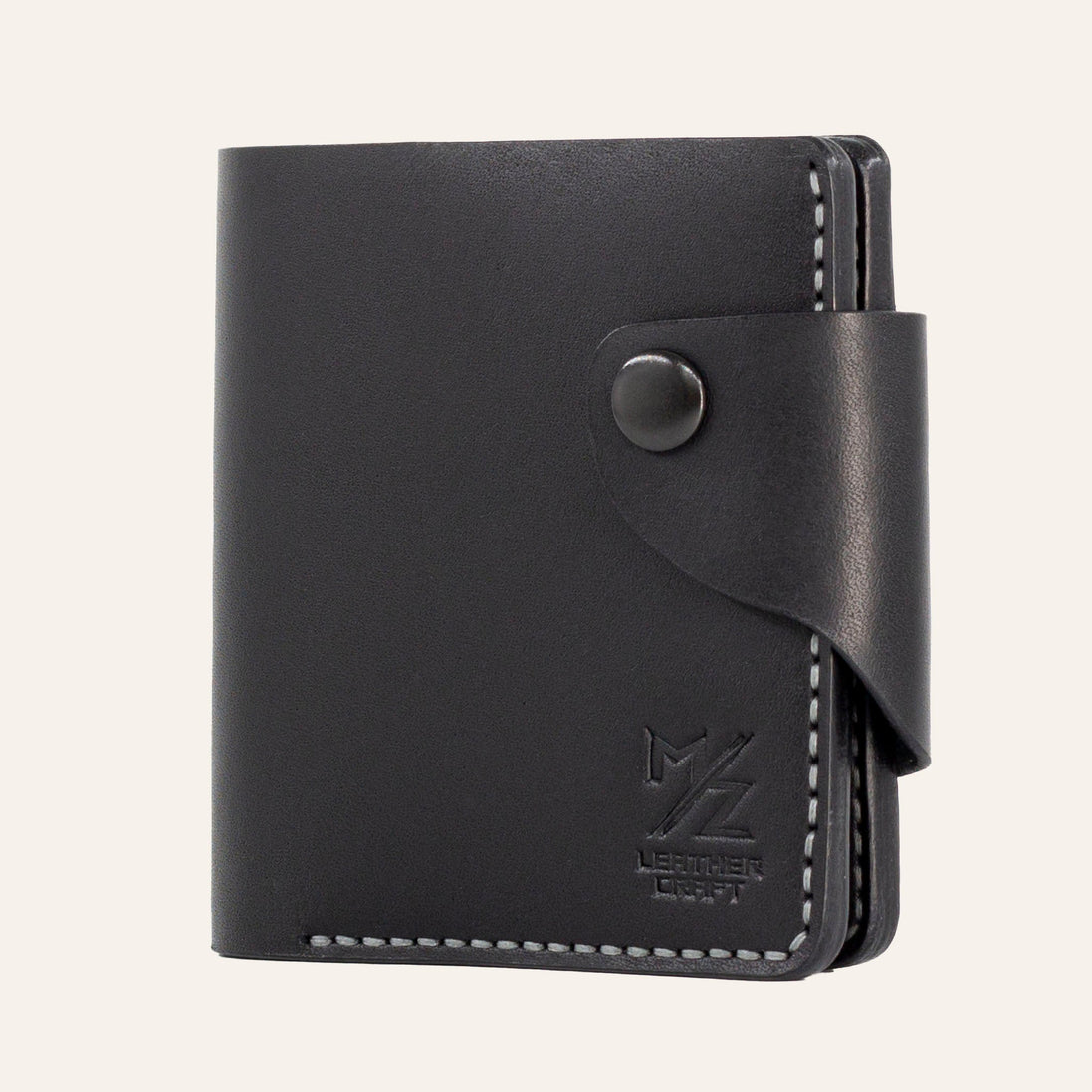 MZ Leather Craft kapalı yatay siyah Buttero deri klasik erkek cüzdanı, ön yüzey dokusunu, kontrast gri el dikişli ön-diyagonal profili ve alt köşedeki kabartmalı MZ logosunu gösteren görünüm