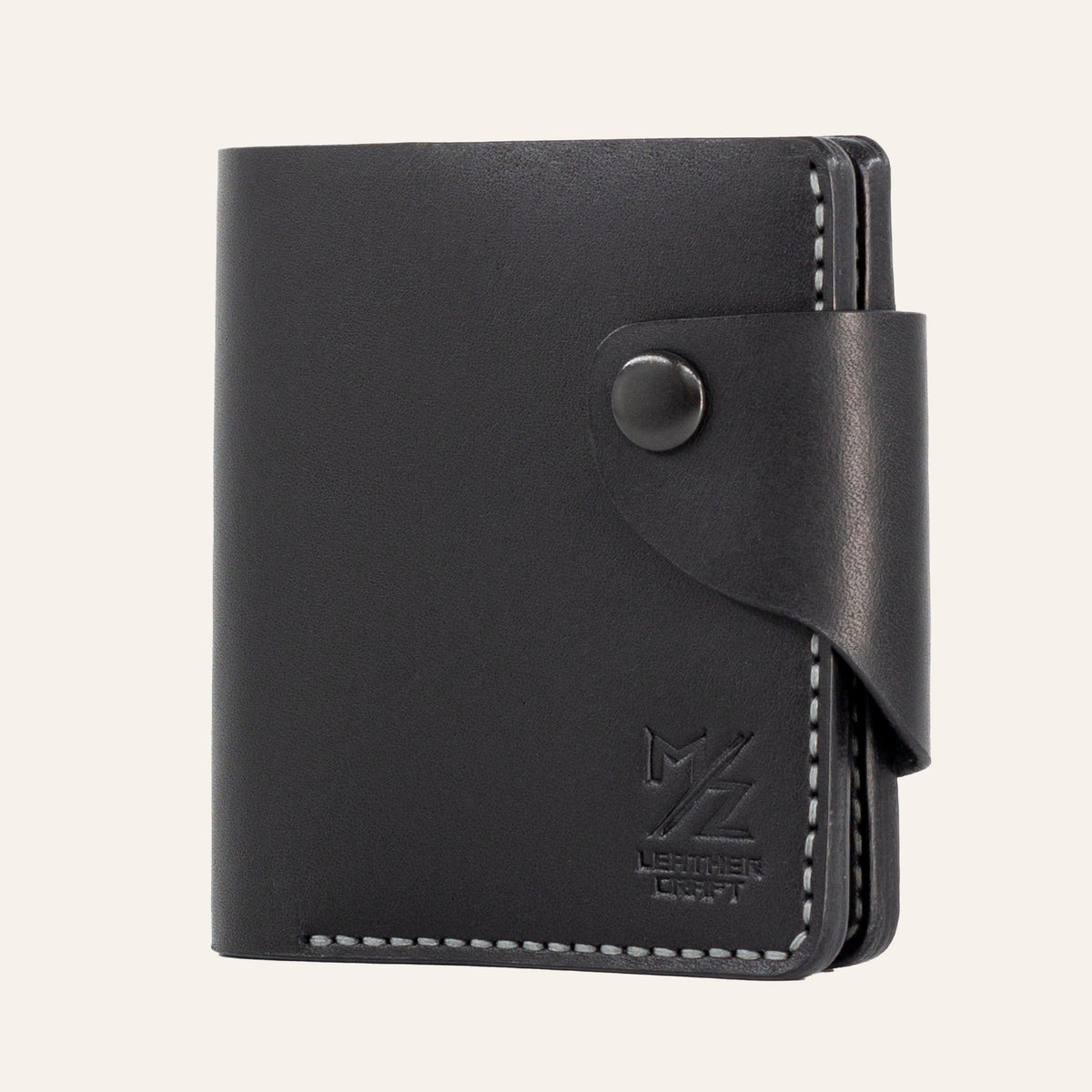 MZ Leather Craft kapalı yatay siyah Buttero deri klasik erkek cüzdanı, ön yüzey dokusunu, kontrast gri el dikişli ön-diyagonal profili ve alt köşedeki kabartmalı MZ logosunu gösteren görünüm