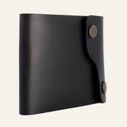 MZ Leather Craft siyah Buttero deri dil kapaklı kompakt cüzdan, kapalı hafif açılı sol profil görünümü ve pürüzsüz deri dokusu