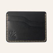 MZ Leather Craft yatay minimalist siyah Buttero deri kartlık, boş kart yuvalarını ve pürüzsüz deri dokusunu gösteren düz ön görünüm, sarı el dikişleri ve kabartmalı MZ logosu
