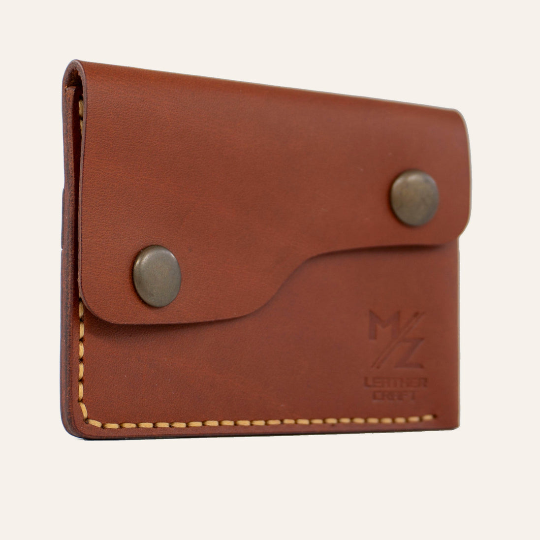 MZ Leather Craft kiremit Buttero deri kapaklı minimalist cüzdan, kapalı hafif açılı sol profil görünümü, sarı el dikişi hattı ve pürüzsüz deri dokusu