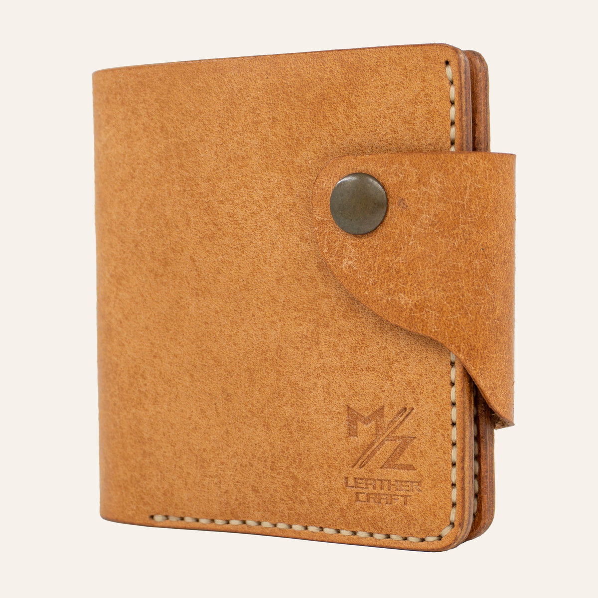 MZ Leather Craft kapalı yatay natürel Pueblo deri klasik erkek cüzdanı, ön yüzey dokusunu, kontrast açık gri el dikişli ön-diyagonal profili ve alt köşedeki kabartmalı MZ logosunu gösteren görünüm