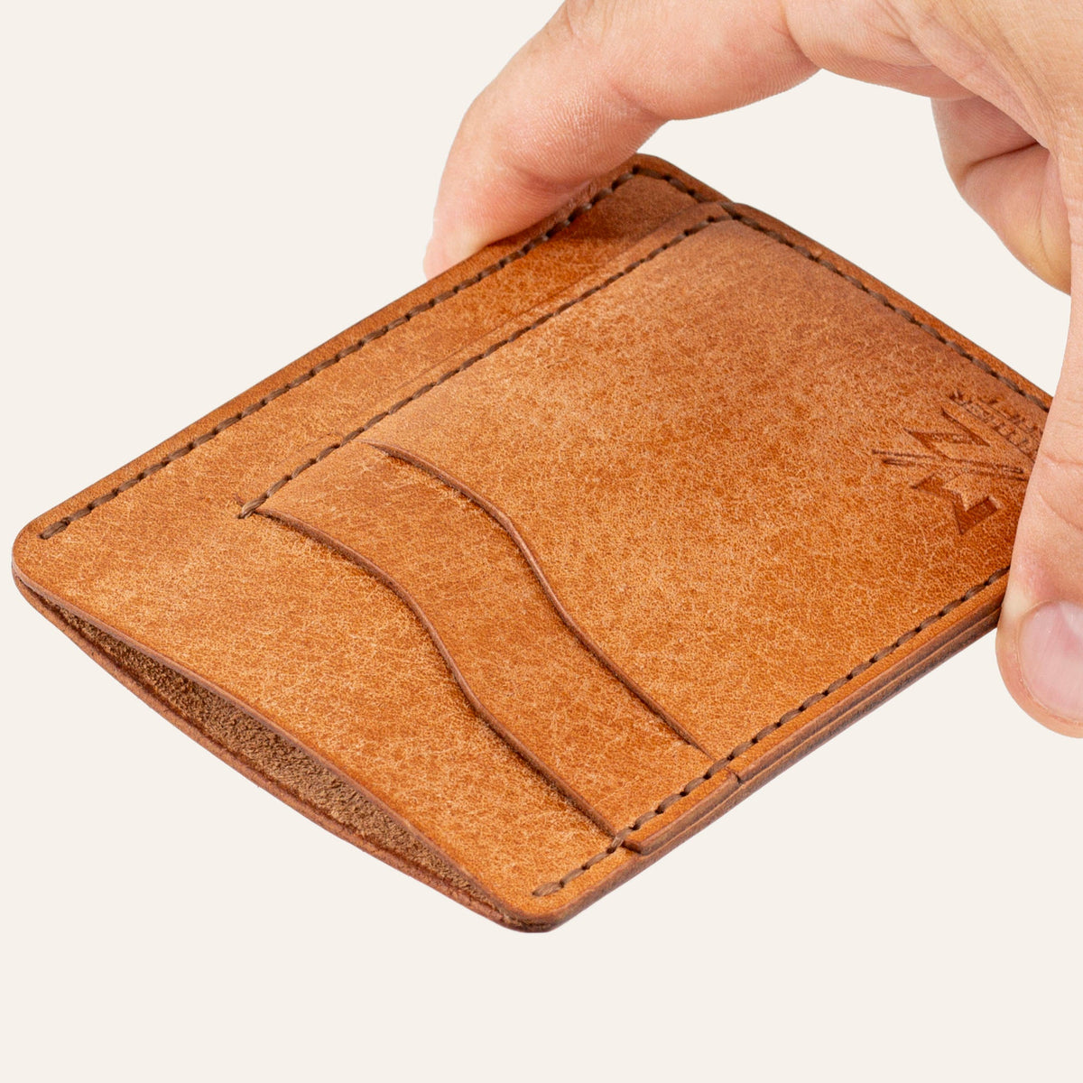 MZ Leather Craft dikey minimalist natürel Pueblo deri kartlık, el ile tutulan hafif açılı boş ön görünüm, kıvrımlı kart yuvaları ve kahverengi saraç dikişi detayları
