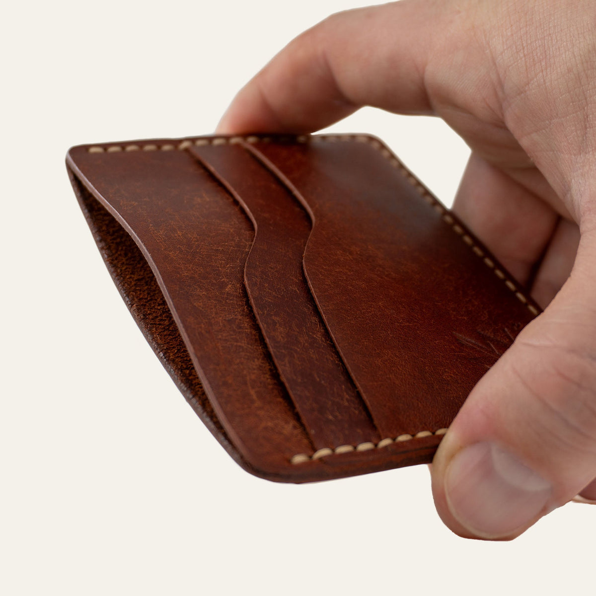 MZ Leather Craft yatay minimalist kiremit Pueblo deri kartlık, el ile tutulan hafif açılı boş ön görünüm, kıvrımlı kart yuvaları ve açık gri saraç dikişi detayları