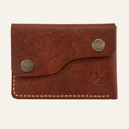 MZ Leather Craft çift çıtçıtlı kapaklı minimalist kiremit Pueblo deri cüzdan, kapalı önden görünüm, asimetrik kapak formu, sarı el dikişi ve kabartmalı MZ logosu