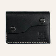 MZ Leather Craft çift çıtçıtlı kapaklı minimalist siyah Pueblo deri cüzdan, kapalı önden görünüm, asimetrik kapak formu, açık gri el dikişi ve kabartmalı MZ logosu